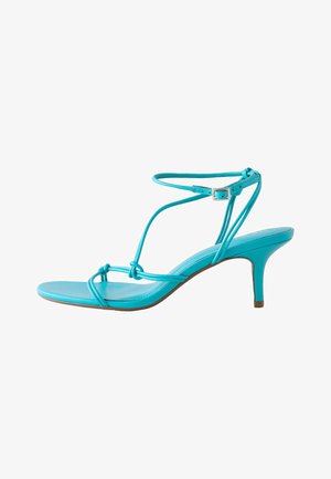 Türkiissinine kõrgete kontsadega sandal õhukeste rihmade, pahkluu pandla, sõlmitud detailide ja saleda, kitsa kontsaga.