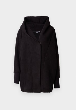 Chaqueta con capucha de forro polar negra con una superficie texturizada, mangas anchas, cierre frontal y un diseño drapeado. El interior es suave.