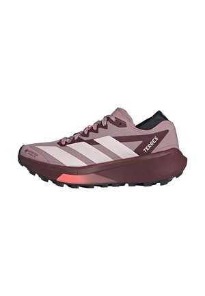 But do biegania trail w kolorze różowym i bordowym z białymi paskami, wytrzymałą podeszwą, wodoodpornym materiałem Gore-Tex oraz logo "Terrex" na boku.