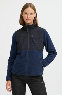 Veste polaire isolante navy avec un panneau noir sur le haut du devant, poches zippées, col montant et tissu texturé.