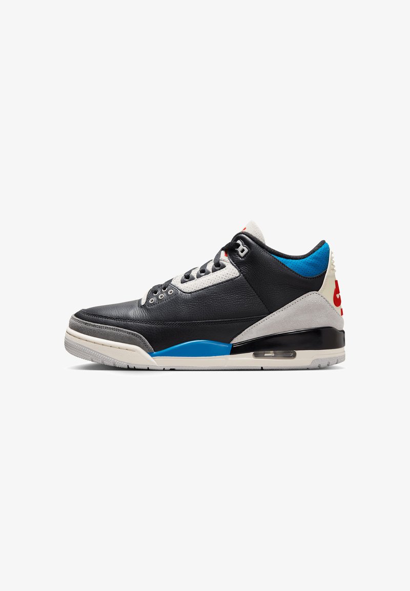 Sneaker nera in pelle con accenti grigi e blu, caratterizzata da una punta testurizzata, chiusura con lacci e ammortizzazione visibile nella suola.