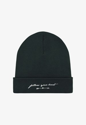 Bonnet noir en tricot avec un revers, comportant un texte brodé en blanc "suis ton cœur" avec un motif de ligne et de flèche.