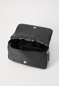 Bolso de cuero sintético negro con una textura suave, enmarcado por herrajes plateados. Cierre de solapa y un compartimento interior con cremallera.