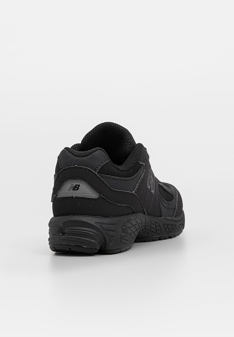 Chaussures de sport noires avec une tige en mesh texturé, un col rembourré et une semelle en caoutchouc. Présente un accent et un logo en argent réfléchissant.
