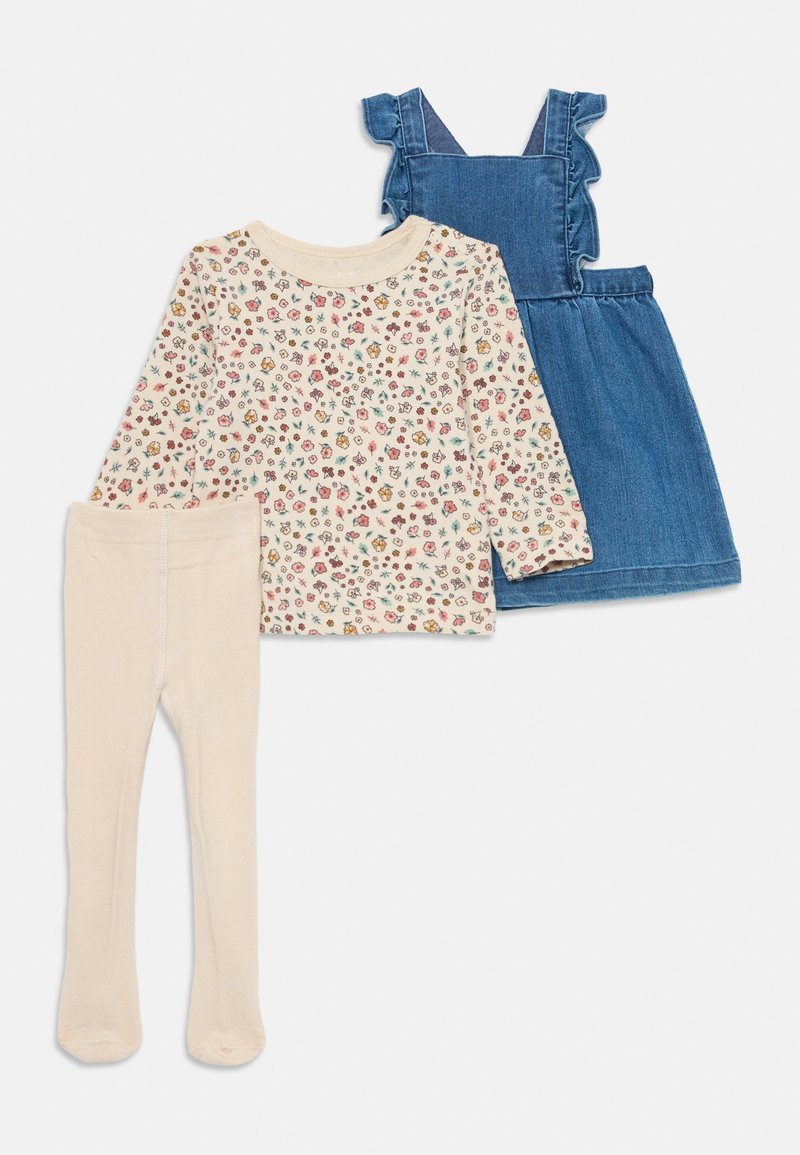 Trzyczęściowy zestaw: kremowa koszula z długim rękawem w kwiatowy wzór, dżinsowa sukienka z falbanami na ramiączkach oraz beżowe legginsy.