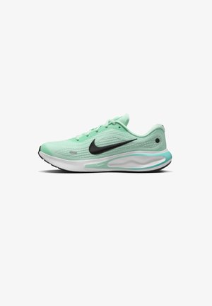 Scarpa sportiva verde chiaro con tomaia testurizzata, logo swoosh nero, intersuola bianca e suola nera. Presenta un design con lacci e un tallone ammortizzato.