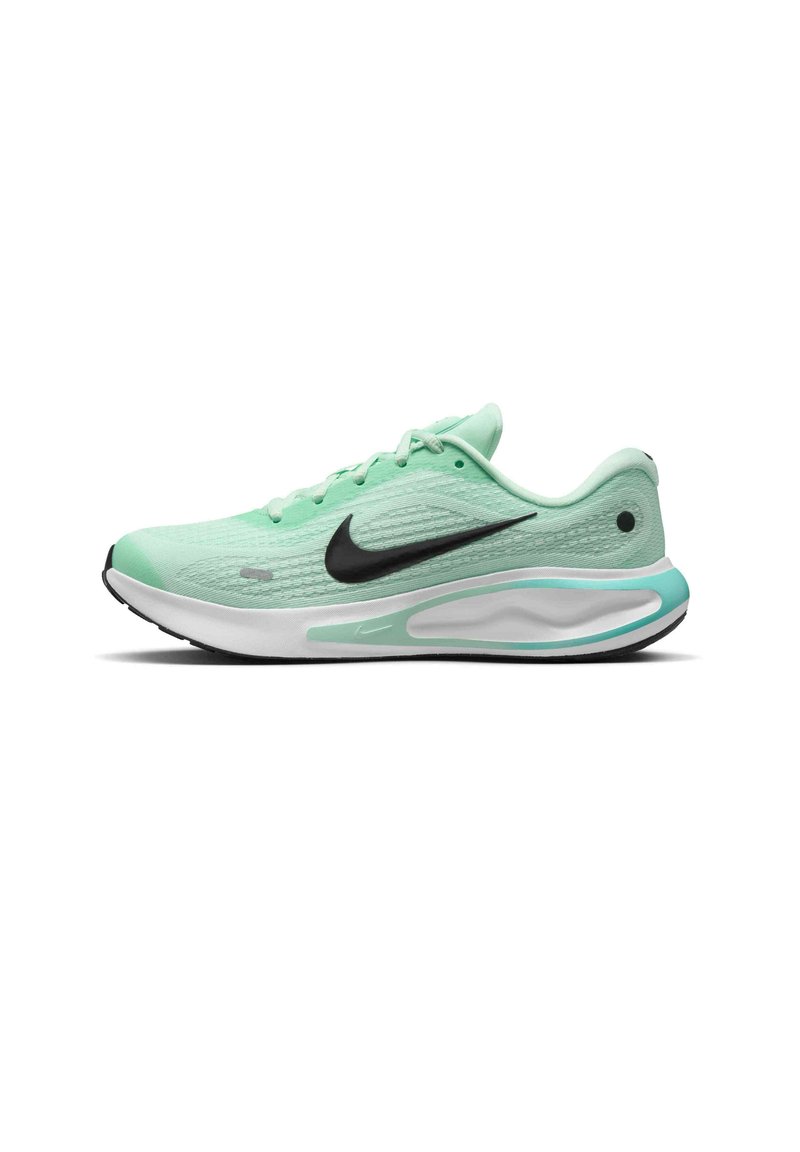 Scarpa sportiva verde chiaro con tomaia testurizzata, logo swoosh nero, intersuola bianca e suola nera. Presenta un design con lacci e un tallone ammortizzato.