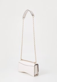 Borsa in pelle bianca con un design curvo, caratterizzata da motivi in rilievo, una tracolla in metallo dorato e una forma strutturata.