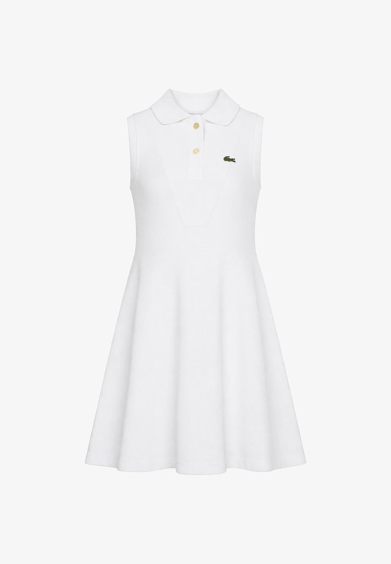 Robe polo blanche sans manches avec jupe évasée, deux boutons et un petit logo crocodile vert sur la poitrine.