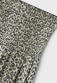 Klänning med leopardmönster och smockad livstycke. Har en blandning av beige, bruna och svarta nyanser, med en flödande kjol och elastisk textur.