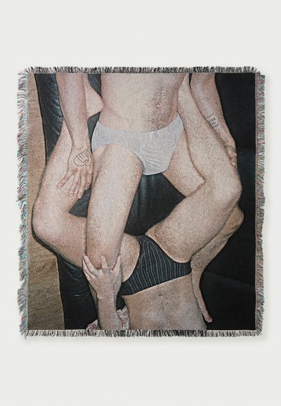 Woven throw blanket featuring a graphic design of human figures in various poses, with fringe edges and a textured finish.
