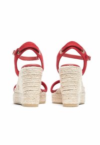 Red suede wedge sandals with a jute-wrapped heel, featuring adjustable ankle straps and a textured sole.