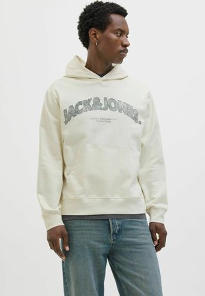 Huppari vaaleasta kermasta, jossa edessä kenguru-tasku, tummanharmaa "JACK&JONES" -grafiikka, ribbireunat käsivarsissa ja kiristettävä huppu. Rentoa istuvuutta.