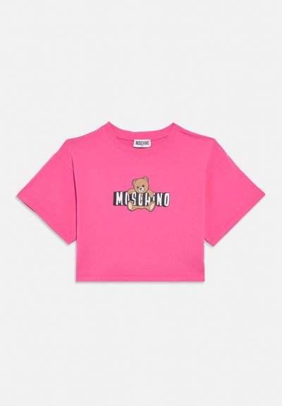 T-shirt court rose vif avec le nom de la marque Moschino et un motif ours en peluche centré à l'avant.