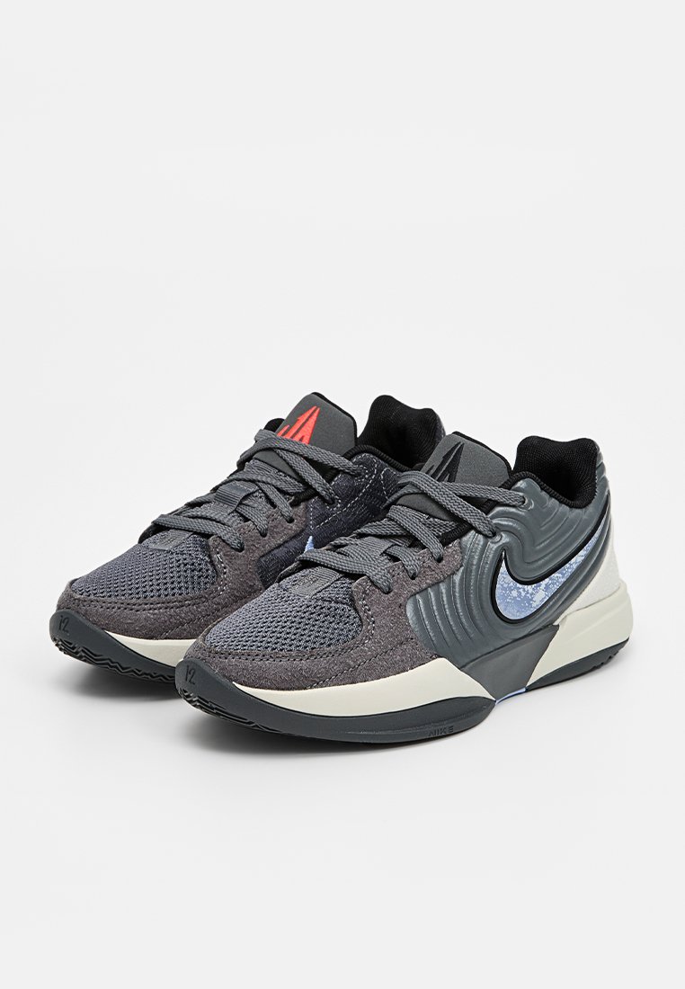 Zapatillas deportivas en negro y gris con parte superior de malla y sintético, collar acolchado, suela texturizada y el prominente logo de Nike.