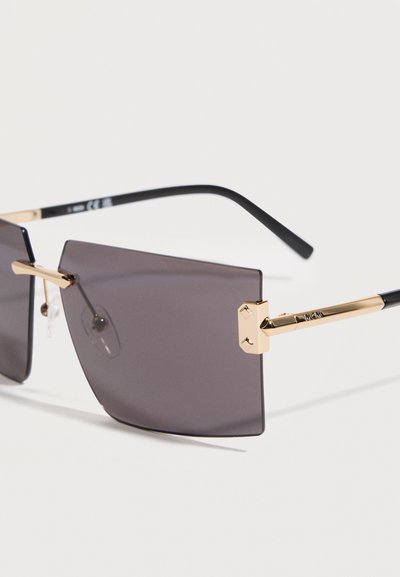 Ορθογώνια μαύρα γυαλιά ηλίου με σκούρο φακό, με χρυσά μεταλλικά μεντεσέδες και μαύρες άκρες στα σκέλη, σε λευκό φόντο.