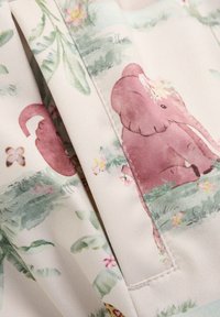Tessuto leggero con un design di elefante rosa, arricchito da accenti floreali, foglie e farfalle su uno sfondo crema; texture sottile visibile.