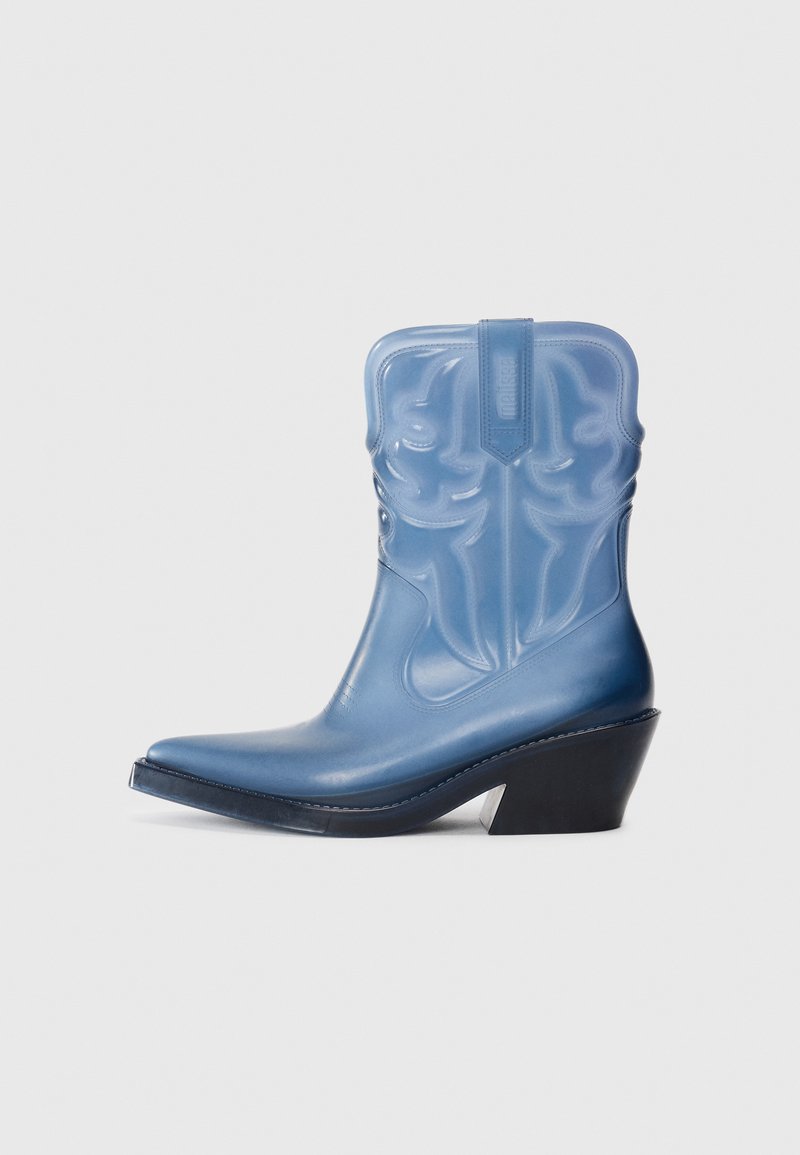 Bota de cowboy de borracha azul com bico pontiagudo, costura decorativa e salto em cunha preto. Cano alto com padrão texturizado.