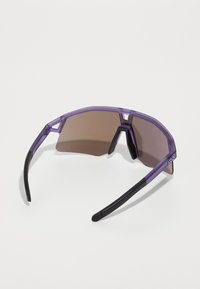 Purple sunglasses with a geometric design, tinted brown lenses, and black accents on the temples, made of lightweight plastic material.