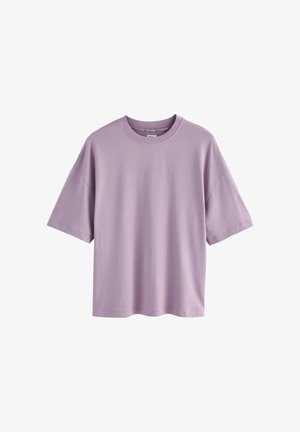 Lillāks oversize īsām piedurknēm kokvilnas T-krekls ar apaļu kakla izgriezumu, attēlots uz baltas fona.