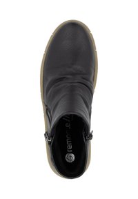 Bottine noire en cuir avec une tige texturée, une construction flexible et des fermetures éclairs sur le côté. La semelle en caoutchouc beige ajoute un contraste au design.
