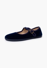 Zapato Mary Jane de terciopelo azul marino con puntera redonda, correa ajustable y suela texturizada negra. Cuenta con un forro interior suave.