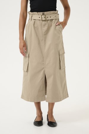 Jupe cargo beige avec taille ceinturée, poches latérales et fente à l'avant, présentant une texture en coton lisse et une longueur au genou.