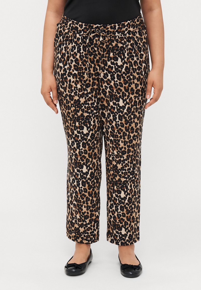 Leoprind-Hosen aus weichem Stoff mit elastischem Bund und Kordelzug. Weit geschnittenes Design und schwarze Schuhe.