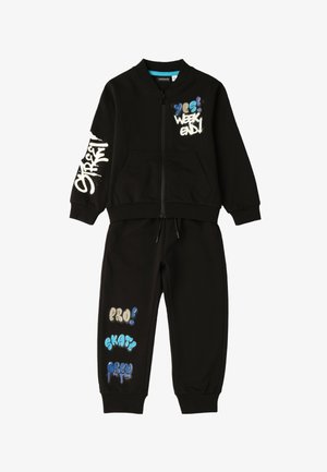 Tuta nera due pezzi con giacca con zip e pantaloni, caratterizzata da testo in stile graffiti: "yes! weekend!", "street", "pro! skate crew."