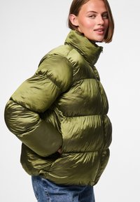 Olive green puffer jacket with a high collar, featuring horizontal stitching, side pockets, and a shiny, textured finish.