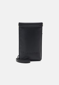 Funda para teléfono de cuero negro con un acabado suave, que cuenta con el logo de Calvin Klein en relieve, cierre superior y correa de hombro desmontable.