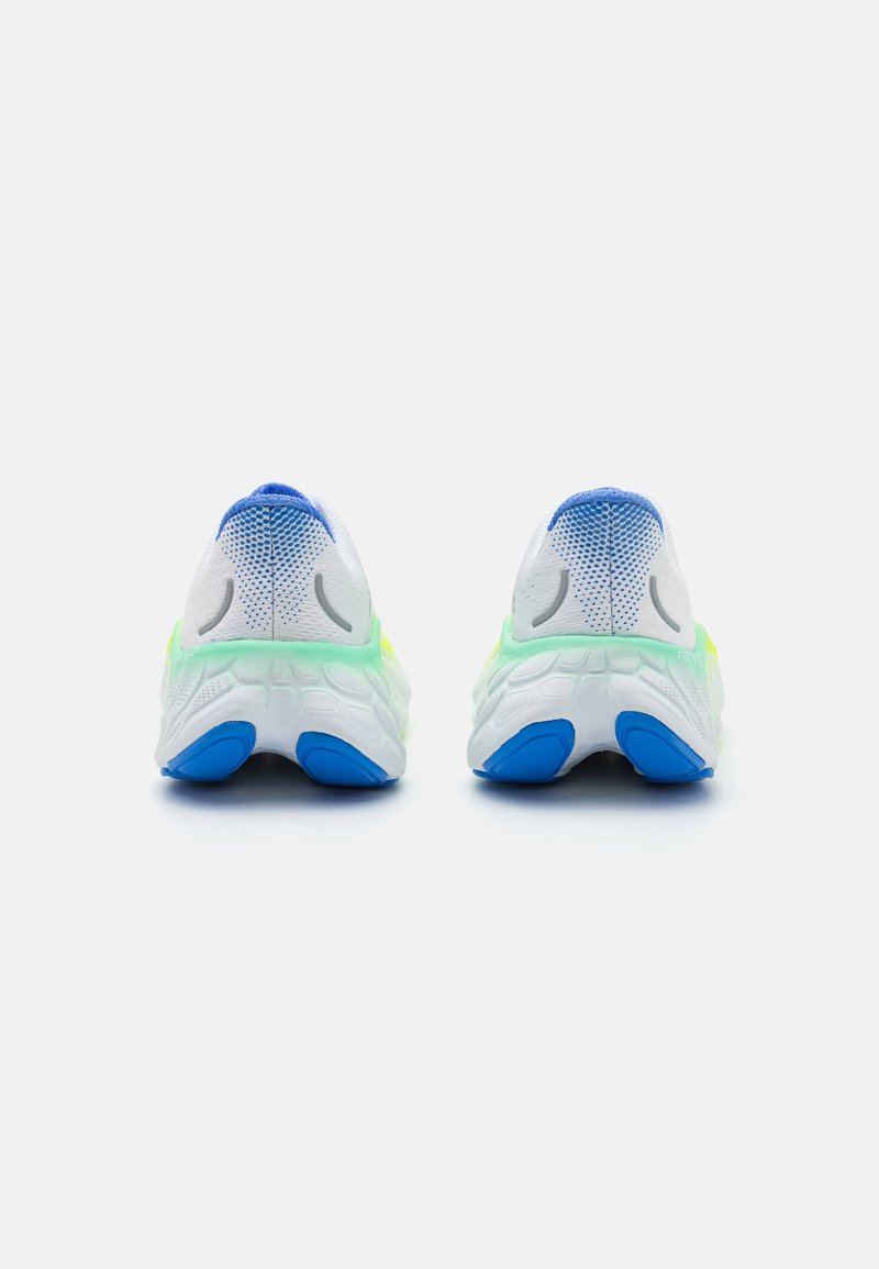 Zapatillas de correr en blanco, con una parte superior de malla y detalles en azul, además de una suela vibrante en amarillo-verde. Se destacan secciones de la suela de goma azul.