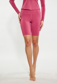 Shorts da biker fucsia a vita alta in un tessuto liscio e elasticizzato, progettati per il massimo comfort con una forma aderente e senza cuciture visibili.