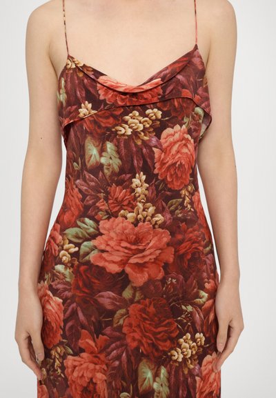 Floral dress featuring a soft, draped neckline, thin straps, and a rich red, green, and cream color palette, with a lush rose pattern.