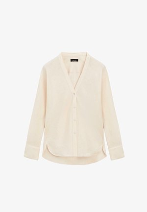 Lyse beige langærmet skjorte med knapper, V-hals og afrundet underkant, vist mod hvid baggrund.