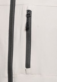 Jasnoszara kurtka zapinana na zamek, wyróżniająca się fakturowaną tkaniną, czarnymi zamkami i przednią kieszenią o eleganckim, minimalistycznym designie.