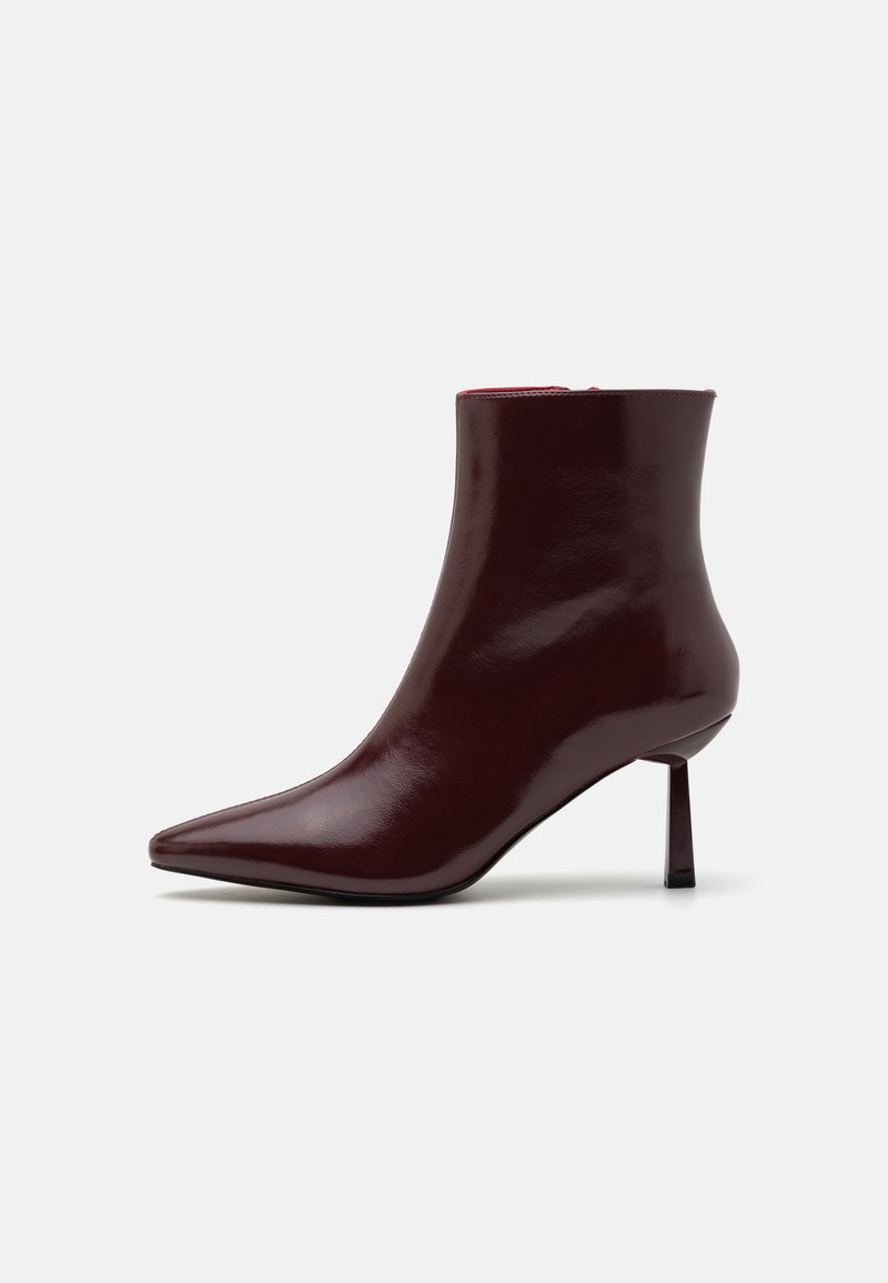 Burgundy patent leather ankle boot with a pointed toe and a slim stiletto heel, featuring a smooth, glossy texture and minimalistic design.