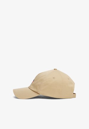 Gorra de béisbol beige con visera curva, hecha de tela texturizada. Cuenta con un pequeño logo bordado en la parte delantera y una correa ajustable en la parte trasera.