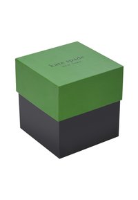 Roheline ülemine kast mustal alusel, millel on kujutatud "kate spade NEW YORK" teksti lillaka värviga. Ükslane tekstuur, ruudu kuju, käepidemed ja servad on puhtad.