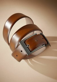 Ceinture en cuir marron avec une finition texturée, dotée d'une boucle rectangulaire en métal noir et de trous pour le réglage.