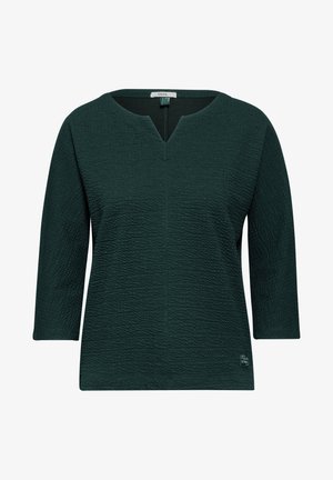 Tmavě zelený top s tříčtvrtečními rukávy, s texturovaným povrchem a výstřihem do V. Značková visačka viditelná na výstřihu.