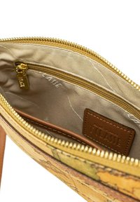 Borsa con zip di colore giallo e motivo terroso all'esterno. All'interno presenta una fodera in tessuto beige, una tasca con zip più piccola e un marchio in pelle marrone.