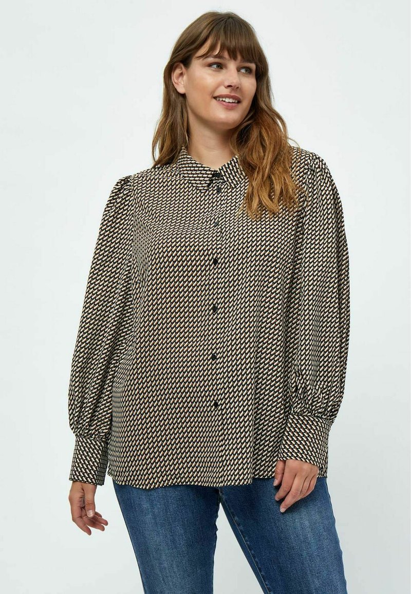 Knapbluse med et geometrisk mønster i sort, creme og brun. Lange, puffede ærmer og kravesnit. Blød stofstruktur.