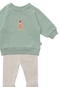 Mint green sweatshirt with a gingerbread man graphic, paired with light grey, ribbed leggings featuring a soft texture and elastic cuffs.