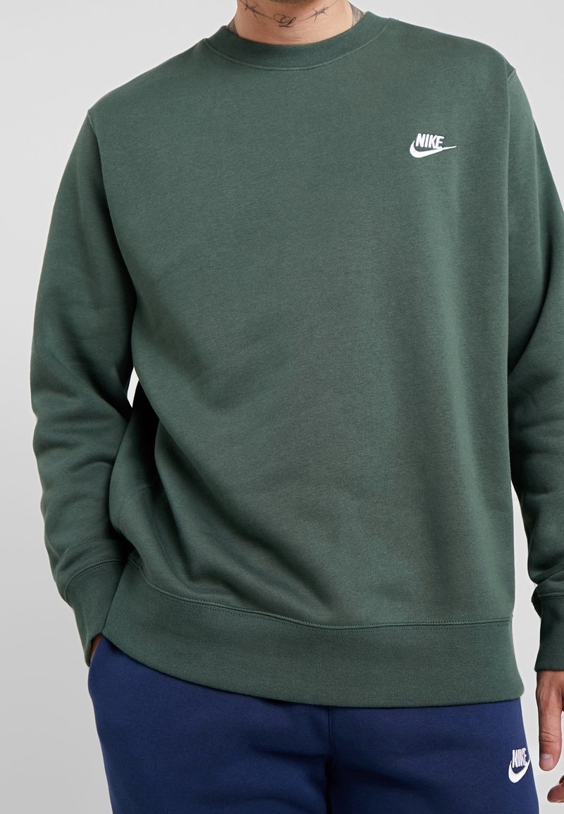Grön Nike sweatshirt med rund halsringning och ribbad mudd. Har en liten vit logotyp på vänster bröst. Mjuk, texturerad tyg.