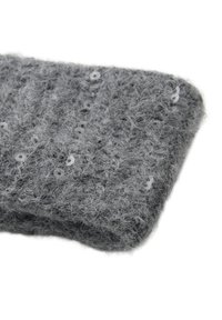 Tessuto a maglia grigio con una trama morbida e pelosa, caratterizzato da piccole paillettes circolari cucite in un motivo uniforme. Design morbido e spesso.