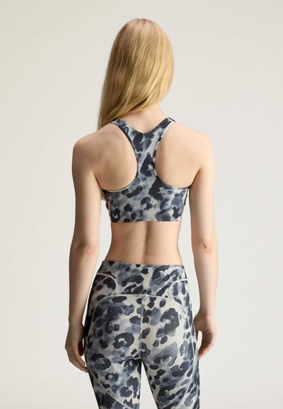 Black and gray leopard print sports bra with a racerback design, paired with high-waisted leggings featuring matching patterns and stitching details.