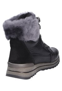 Botte noire à la cheville avec un revers en fausse fourrure grise, en cuir et en daim, et une semelle en caoutchouc gris texturé avec un léger talon.