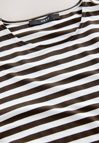 Brun- och vitrandig topp med rund halsringning, tillverkad i mjukt tyg, med jämnt fördelade horisontella ränder och en märkesetikett.