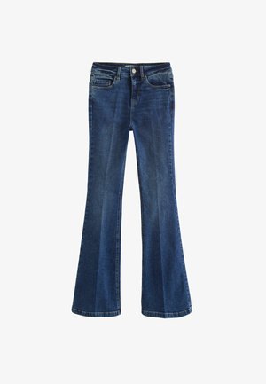 Vidutinio mėlynumo džinsiniai platūs džinsai, su standartine juosta, priekinėmis kišenėmis ir šiek tiek nudėvėta išvaizda, kuri suteikia tekstūros kontrastą.